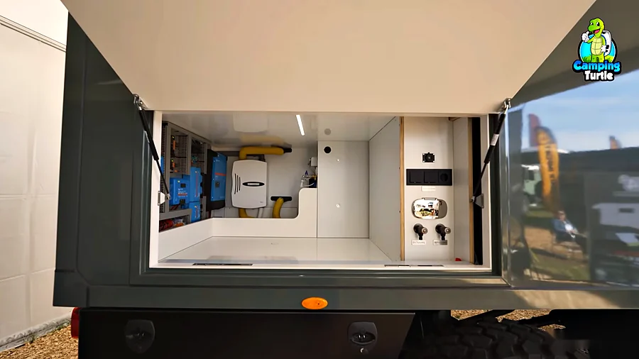 Geöffnete Heckgarage des X4Quadrat Steyr 12M25 mit Victron-Technik, Außendusche und Anschlüssen für Entnahme und Befüllung
