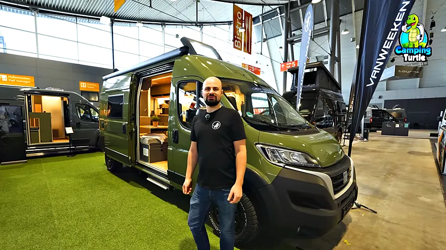 Pascal Rottinger vor dem olivgrünen VanWeekend AJOSS 600 auf Fiat Ducato mit geöffneter Schiebetür auf der CMT 2026
