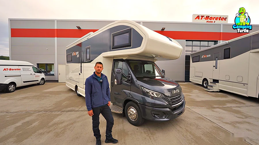 Daniel Tigges steht vor dem ATventure 870 auf Iveco Daily, im Hintergrund die Halle von AT-Boretec