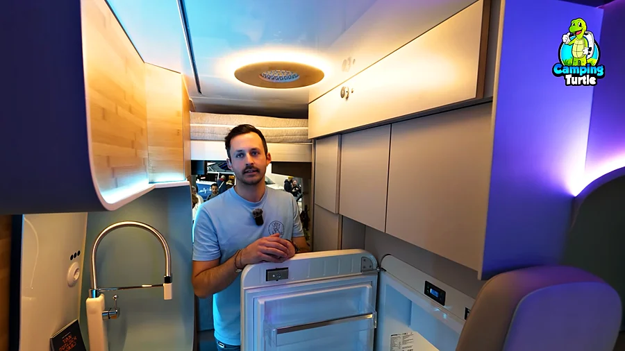 Christian Dinraths hinter dem geöffneten Smeg-Kühlschrank, links die Smeg-Armatur.