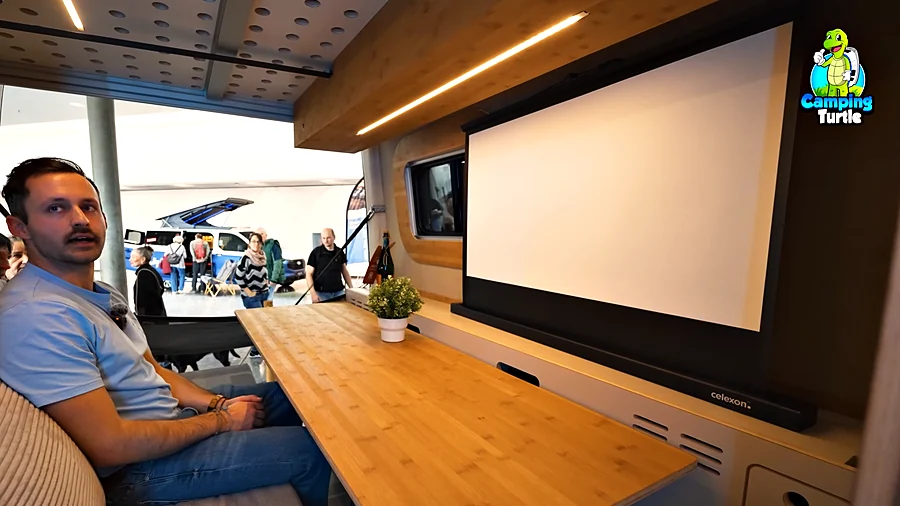 Christian Dinraths sitzt in der Heck-Lounge am langen Bambustisch, gegenüber eine Leinwand von Celexon.