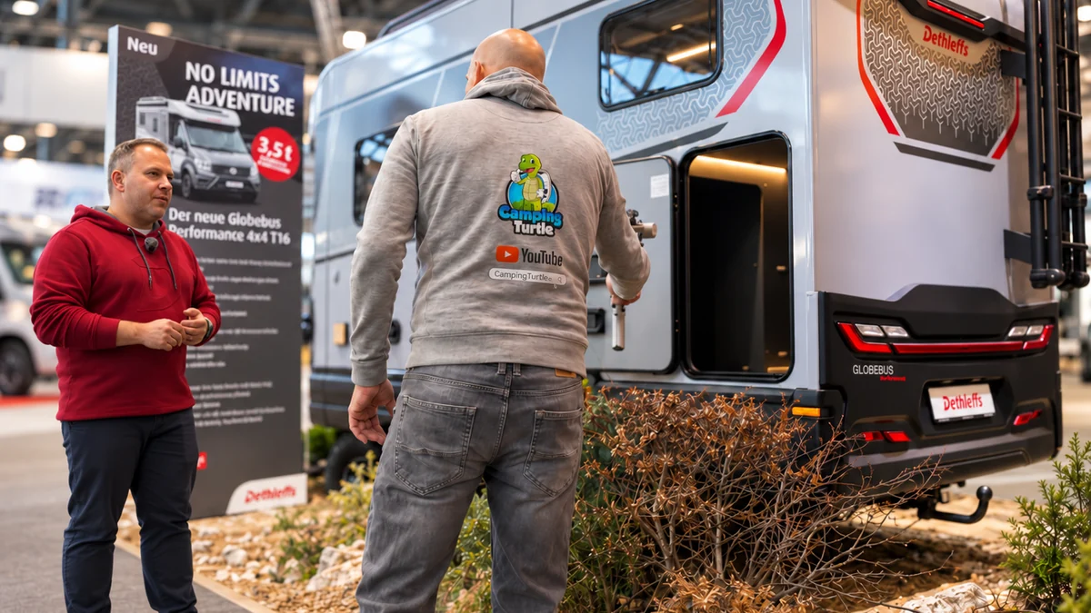 Thomas von CampingTurtle im Gespräch mit einem Experten von Dethleffs vor einem Globebus auf einer Messe