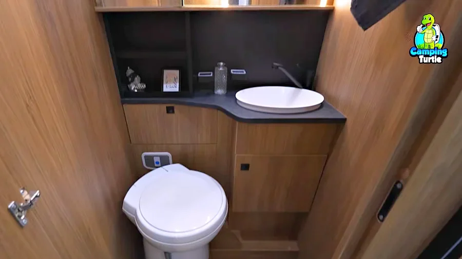 Waschraum mit Toilette, Waschbecken und Holzwänden im Challenger 317 Cosy Edition