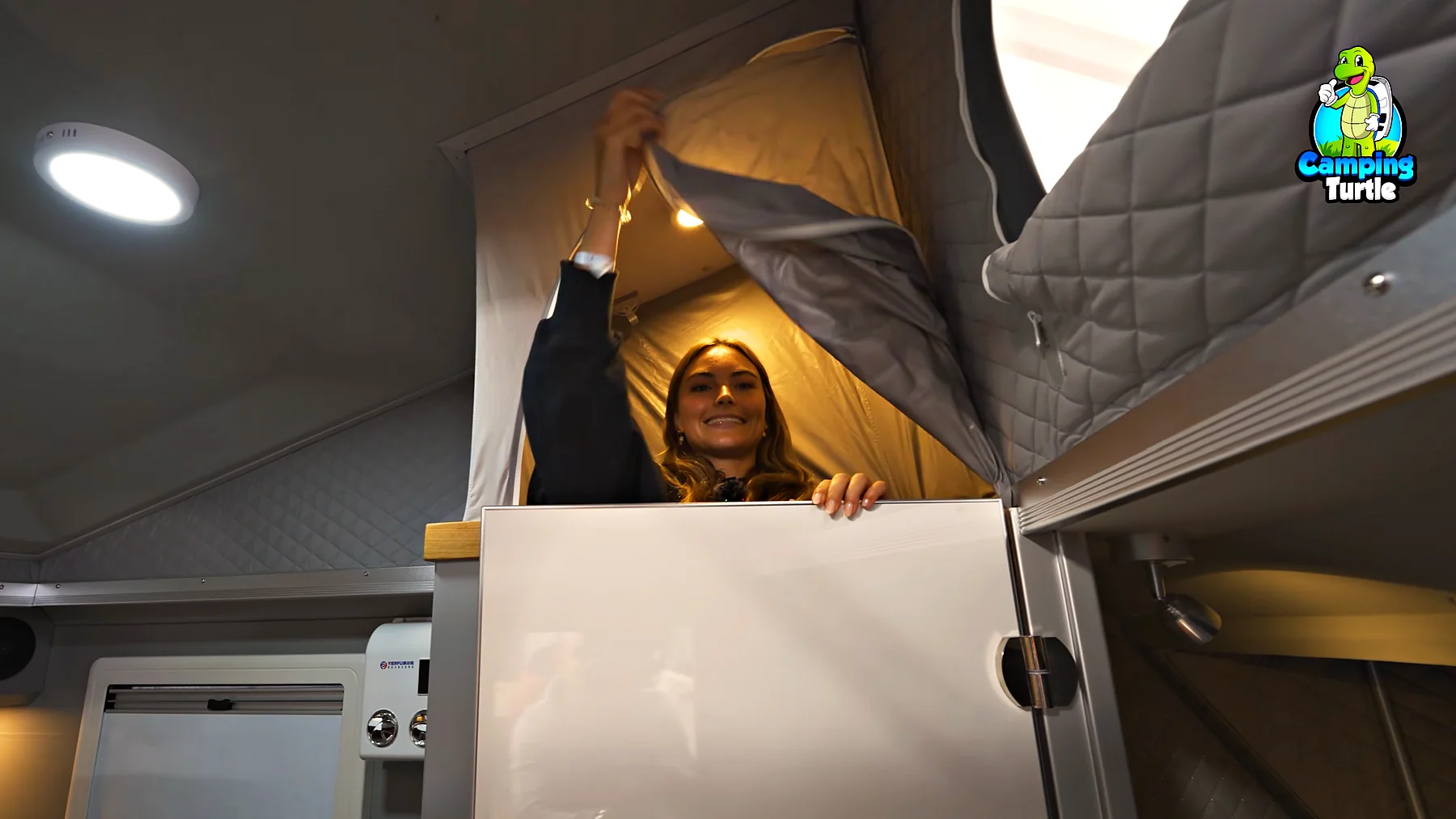 Jil steht in der Dusche hinter der halb geöffneten Badtür, darüber das ansteigende Dach