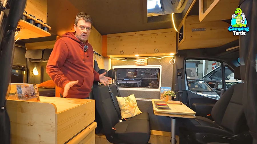 Martin Hemp in der Sitzgruppe des Flowcamper MAX mit Tisch und gedrehtem Beifahrersitz