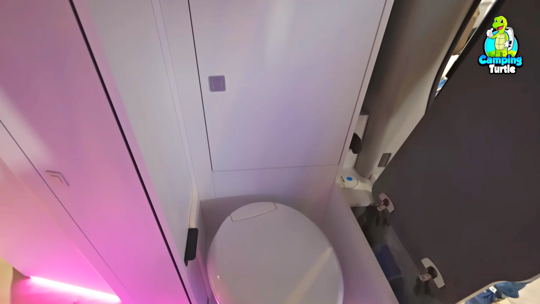 Blick von oben auf die eingebaute Toilette neben dem schmalen Schrank im Heck.