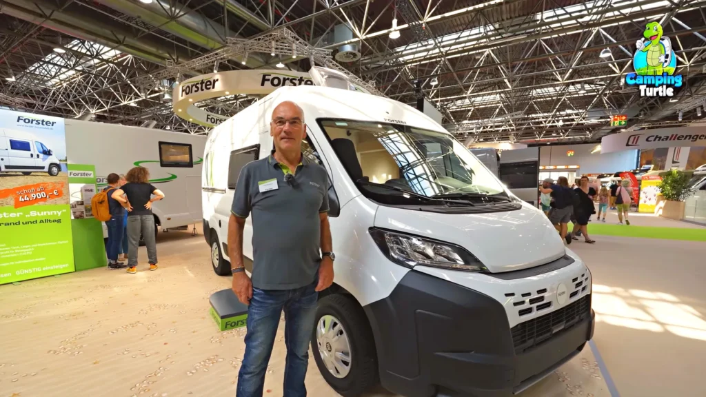 Detlef Bussenius vom Forster-Messeteam steht vor dem weißen Forster Youngster Sunny auf Fiat Ducato am Messestand
