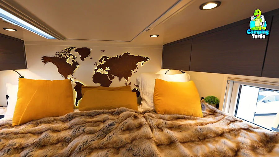 Längsbett mit Felldecke und gelben Kissen vor einer hinterleuchteten Weltkarte aus Cortenstahl