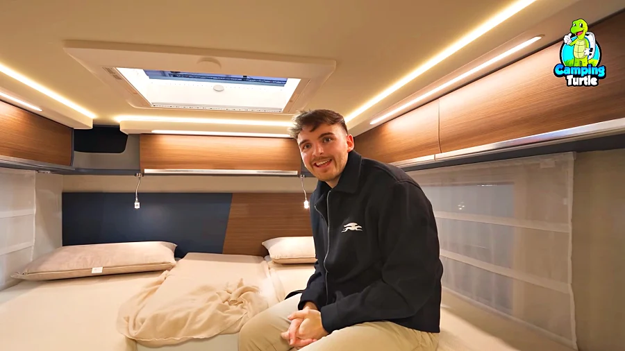Marcel Carli sitzt auf den Längsbetten im Heck