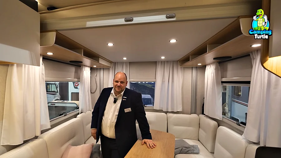 Marco Sander steht in der Hecksitzgruppe des Pilote P720U am Tisch, dahinter drei Fenster