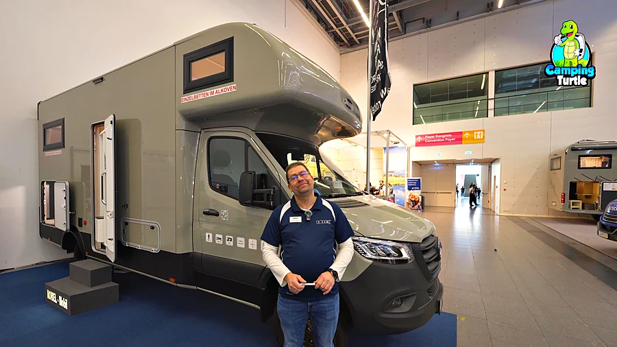 Carsten Lührmann steht vor dem Robel Mobil K 700 HLB auf Mercedes Sprinter in einer Messehalle