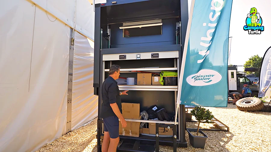 Abgesenkte Hubgarage am Heck des Torax Off Grid mit geöffnetem Rolltor und Regalen