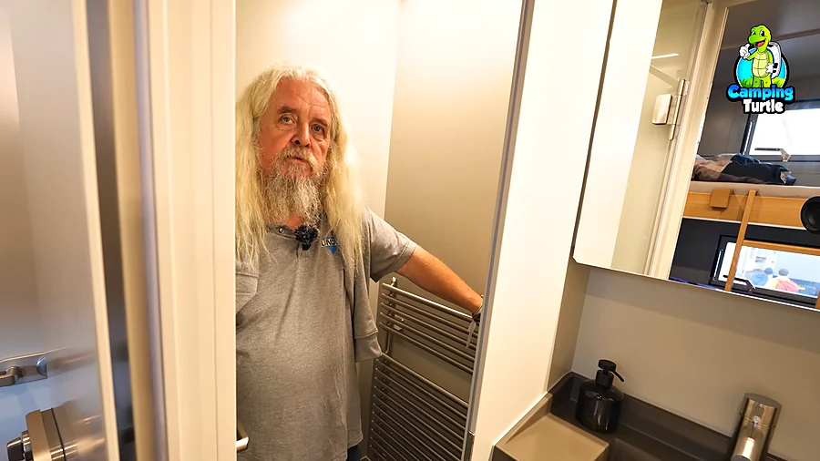 Thomas Waas im Bad des UNICAT MAN TGS mit Handtuchheizkörper und Waschbecken