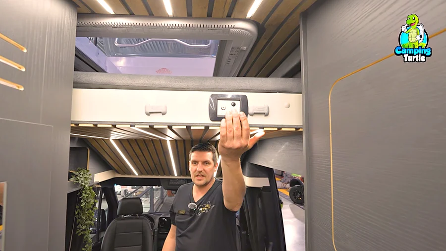 Michael Rottmann zeigt das elektrische Hubbett über dem Fahrerhaus des Wiemobil 740