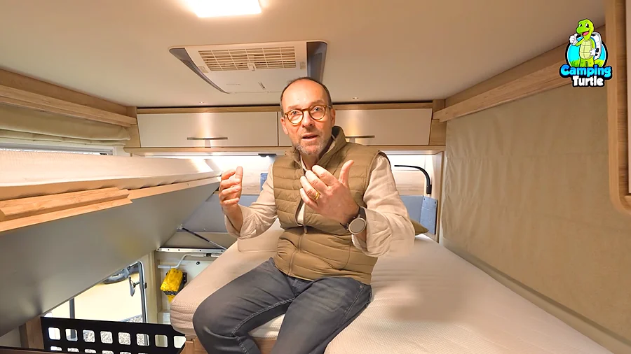 Frank Lessmann im Heck des Eura Mobil Xtura XT 686 EF, unter dem hochgeklappten Bett sitzt die Bordsteuerung