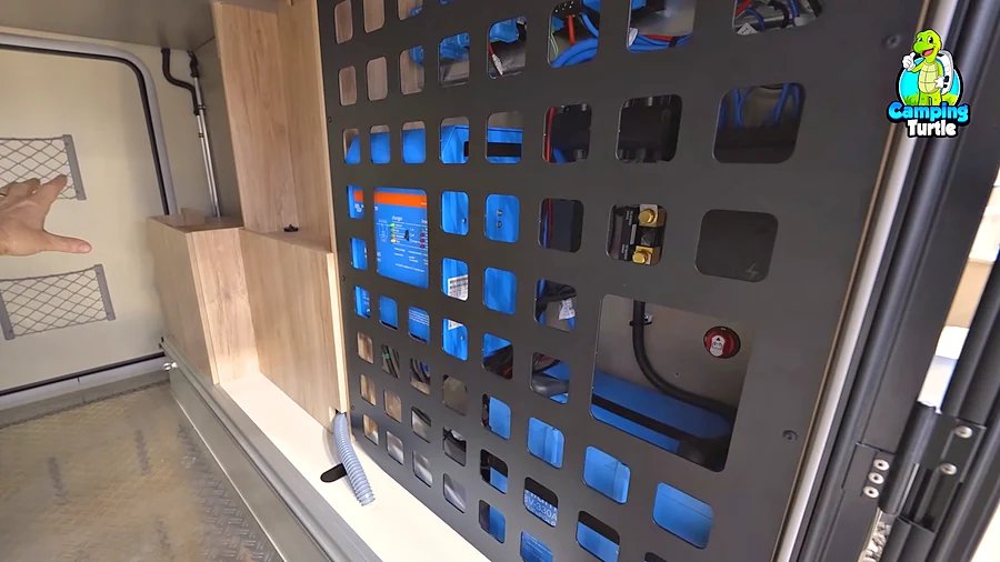 Elektrik von Victron hinter einem schwarzen Schutzgitter in der Heckgarage