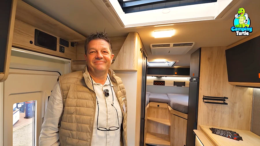 Marco Abel im Wohnraum des Eura Mobil Xtura Xplorer, im Hintergrund das Bett im Heck