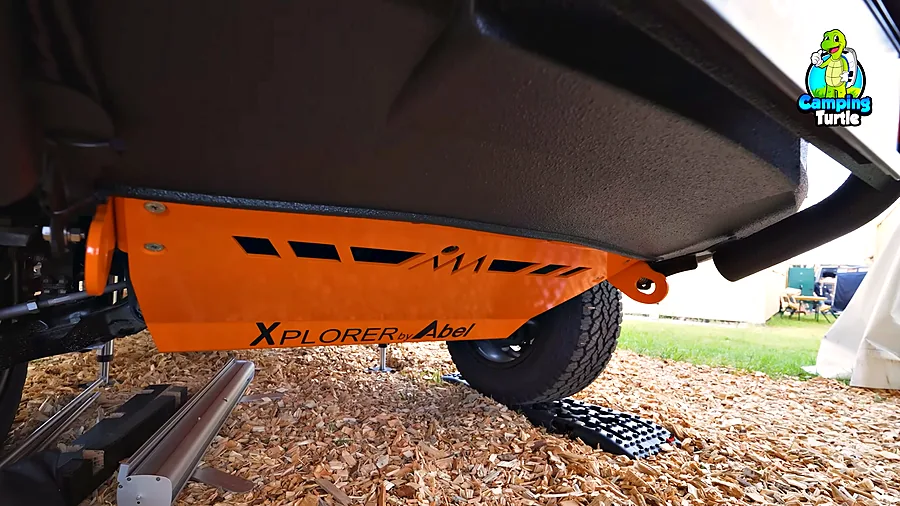 Orangefarbener Unterfahrschutz aus Aluminium mit Xplorer-by-Abel-Schriftzug unter dem Abwassertank